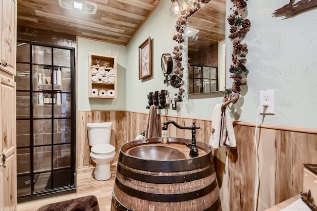 interior space featuring hardwood / wood-style flooring, wooden walls, toilet, and wooden ceiling