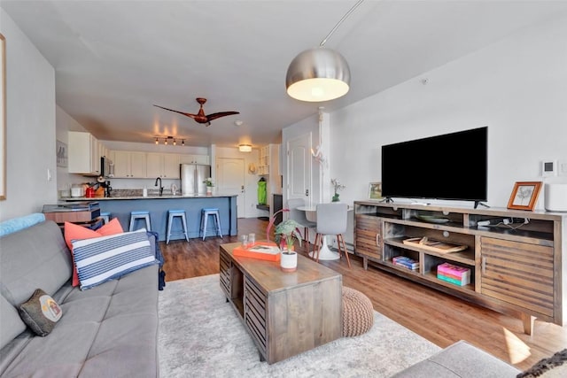 living room featuring a ceiling fan and light wood-style flooring