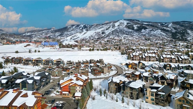 snowy aerial view with a mountain view and a residential view