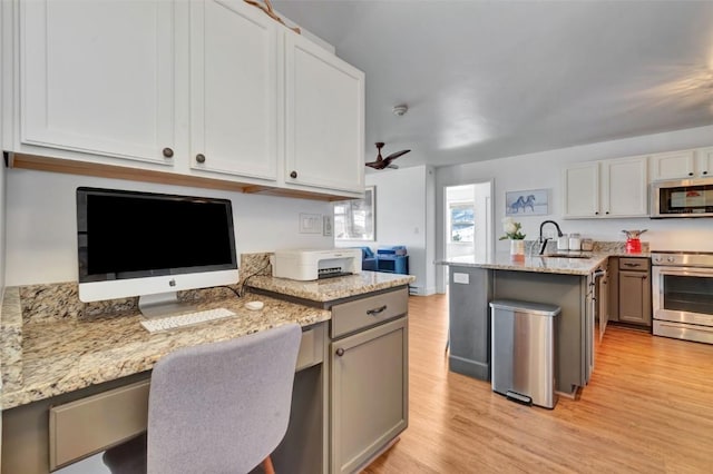 kitchen featuring ceiling fan, light wood-style flooring, stainless steel appliances, a sink, and light stone countertops