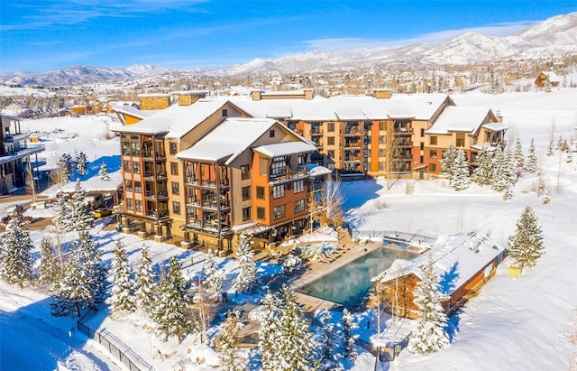 snowy aerial view featuring a mountain view