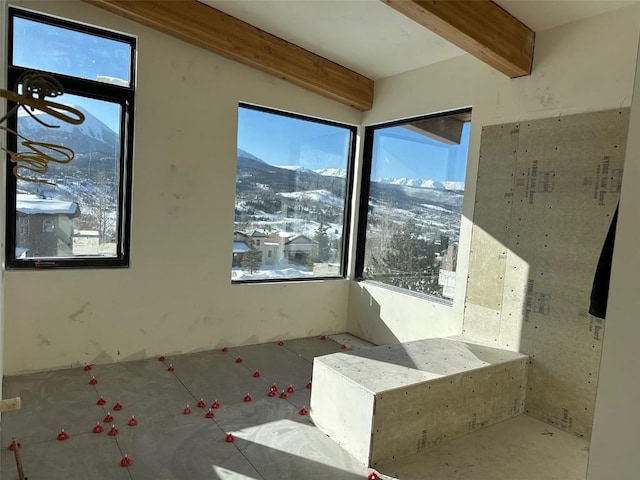 unfurnished sunroom featuring a mountain view and a wealth of natural light