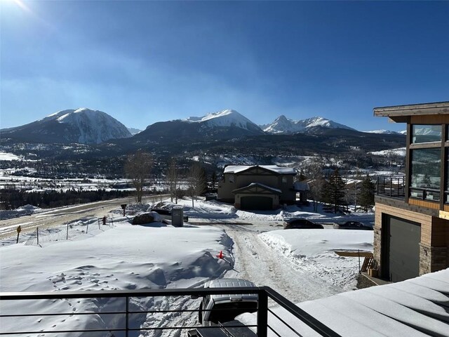 snow covered deck with a mountain view