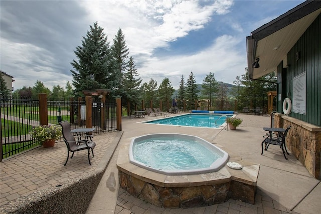 view of swimming pool featuring a community hot tub and a patio