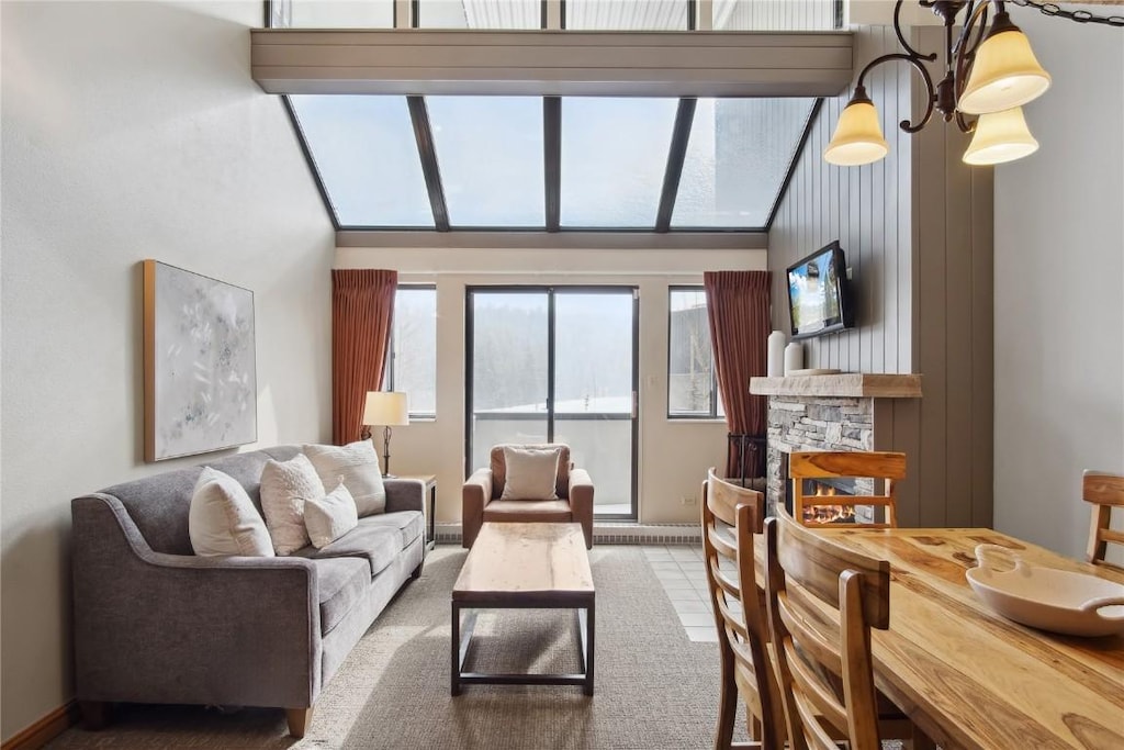 tiled living room with a stone fireplace