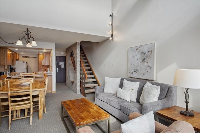 carpeted living room with a chandelier and rail lighting