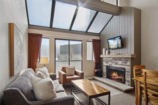 living room with a stone fireplace, wooden walls, and high vaulted ceiling