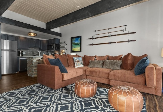 living room featuring beamed ceiling and dark wood-style flooring