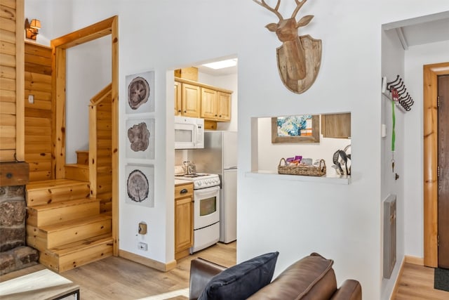 kitchen featuring light hardwood / wood-style floors, white appliances, and light brown cabinetry