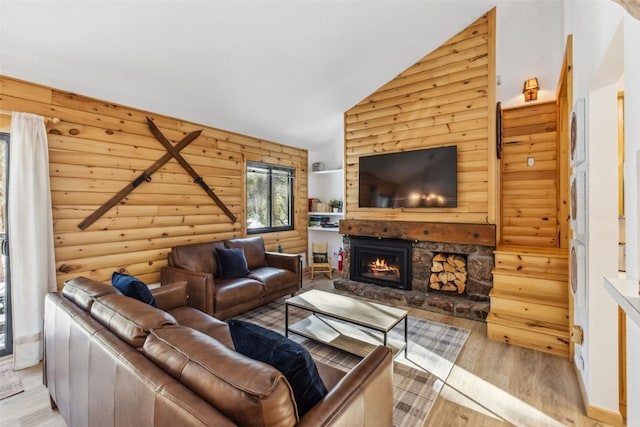 living room featuring a fireplace, light wood-type flooring, rustic walls, and lofted ceiling