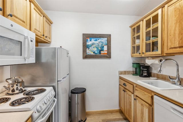 kitchen featuring light wood-type flooring, white appliances, and sink