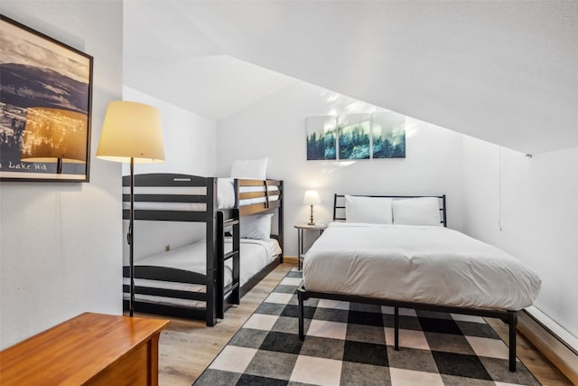 bedroom featuring hardwood / wood-style flooring and vaulted ceiling