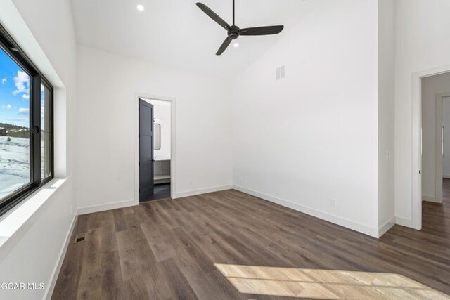 spare room featuring lofted ceiling, ceiling fan, and dark wood-type flooring