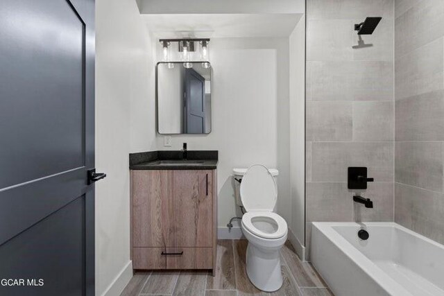 full bathroom with vanity, toilet, and tiled shower / bath