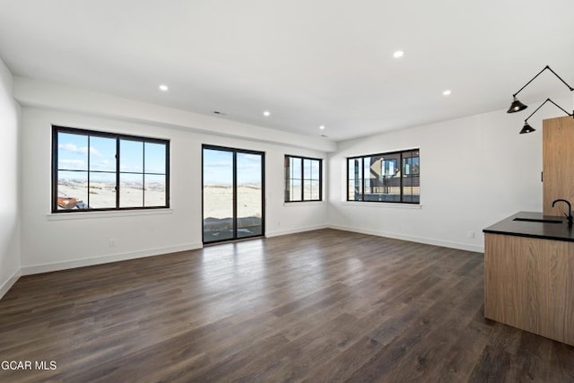 unfurnished living room featuring dark hardwood / wood-style flooring and sink