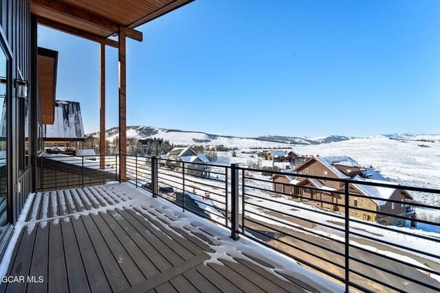 snow covered deck with a mountain view