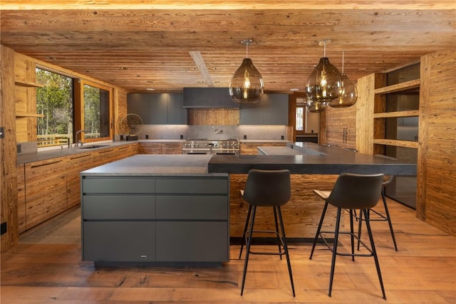 kitchen featuring gray cabinetry, light hardwood / wood-style floors, a kitchen bar, and wood ceiling