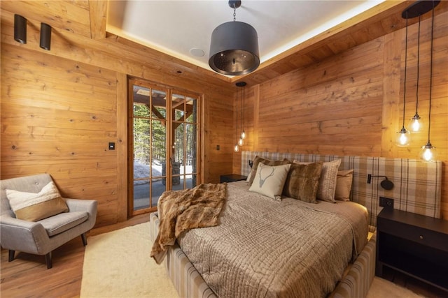 bedroom featuring access to exterior and wood walls