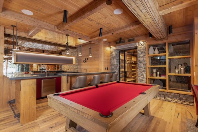 recreation room with beam ceiling, light wood-type flooring, indoor bar, and pool table