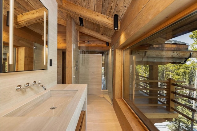 bathroom featuring sink, vaulted ceiling with beams, wood walls, and wood ceiling