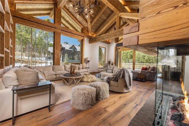 sunroom / solarium with wood ceiling, lofted ceiling with beams, and a notable chandelier