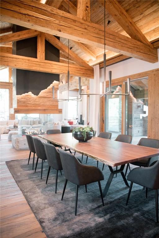 dining space featuring beamed ceiling, wooden ceiling, hardwood / wood-style floors, and a wealth of natural light