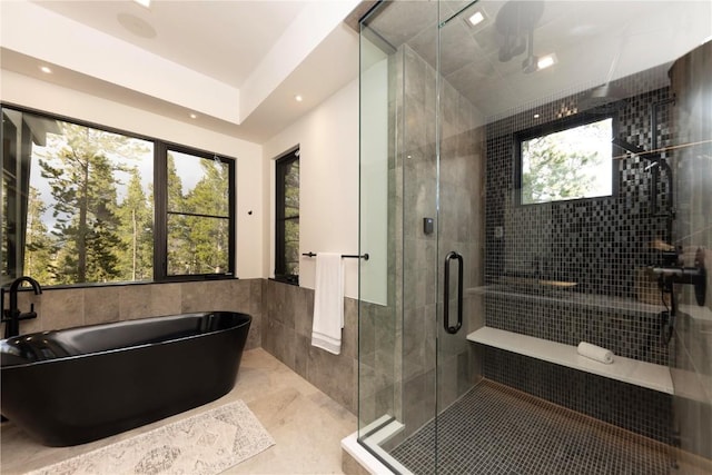 bathroom with tile patterned floors, separate shower and tub, and tile walls