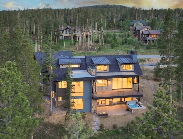 back house at dusk with a balcony