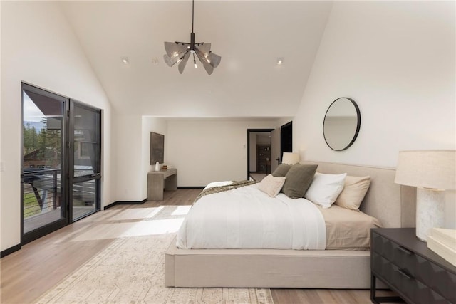 bedroom with high vaulted ceiling, access to outside, an inviting chandelier, and light hardwood / wood-style floors