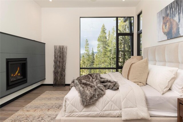 bedroom with a fireplace and dark hardwood / wood-style flooring