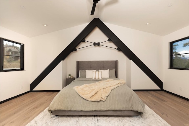 bedroom with wood-type flooring and vaulted ceiling