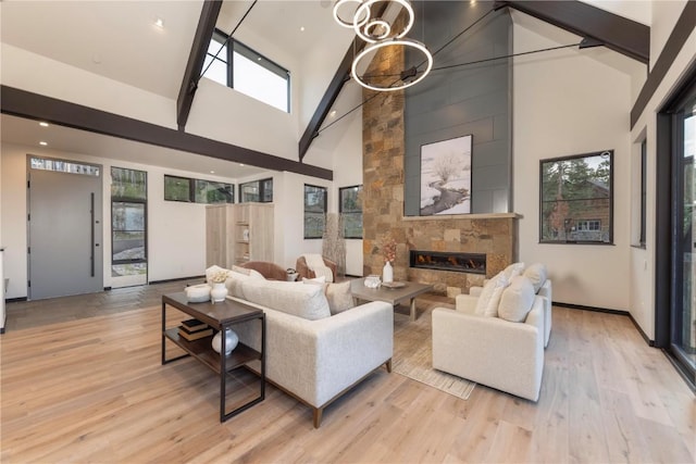 living room featuring a wealth of natural light, a fireplace, high vaulted ceiling, and light hardwood / wood-style flooring