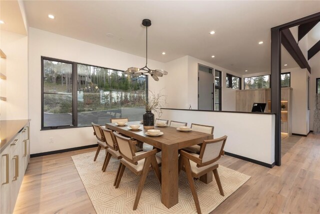 dining space with a chandelier, plenty of natural light, and light hardwood / wood-style floors