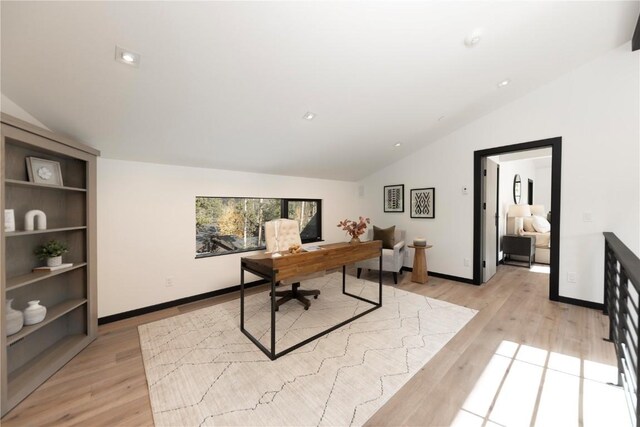 office area with light hardwood / wood-style floors and vaulted ceiling