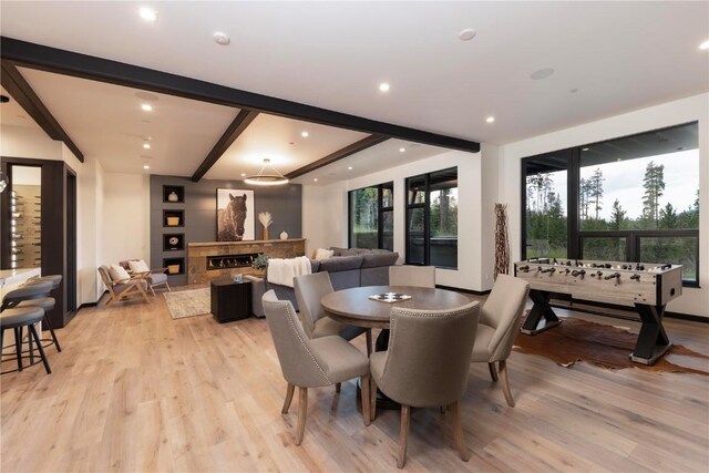 dining space with beamed ceiling and light hardwood / wood-style floors