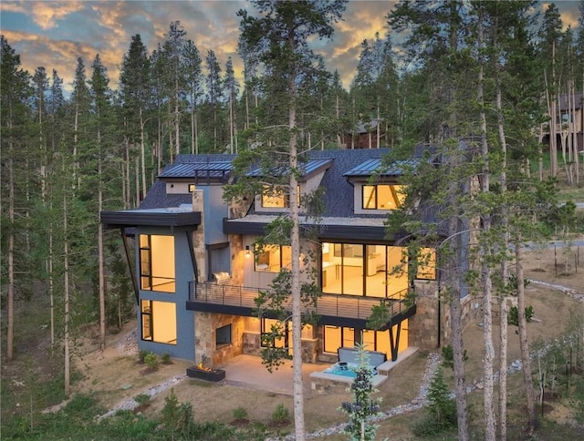 back house at dusk with a patio