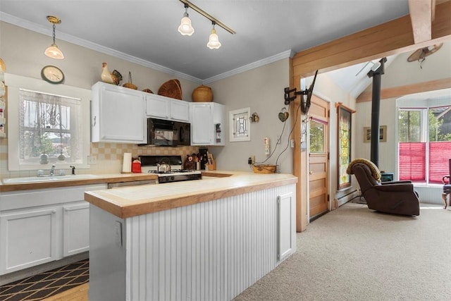 kitchen featuring pendant lighting, range, sink, tasteful backsplash, and white cabinetry