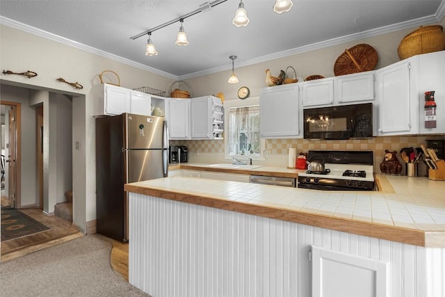 kitchen featuring pendant lighting, black appliances, white cabinets, tile counters, and kitchen peninsula