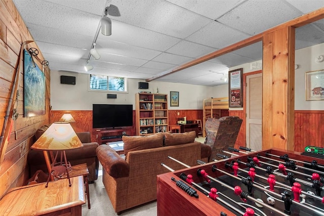 game room with light carpet, rail lighting, and wood walls