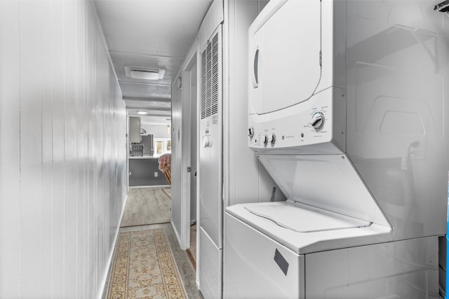 washroom with laundry area, stacked washer / dryer, and light wood-style flooring