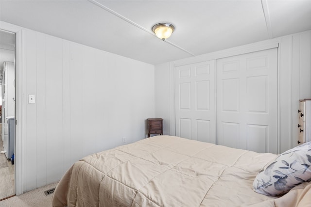 bedroom with light carpet and a closet