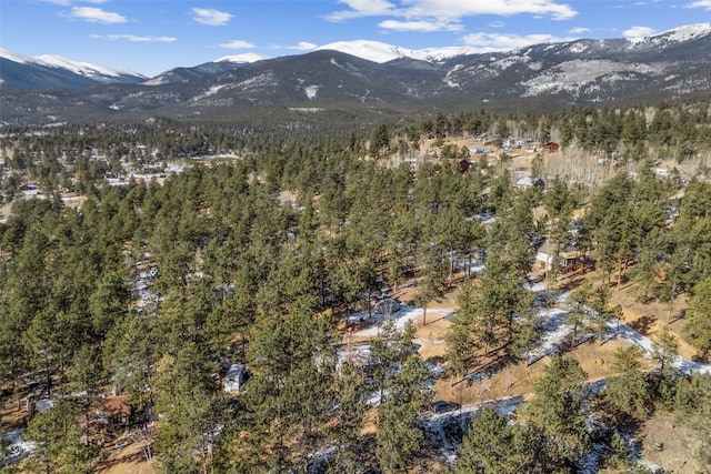 drone / aerial view with a wooded view and a mountain view