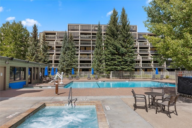 view of swimming pool with a community hot tub and a patio