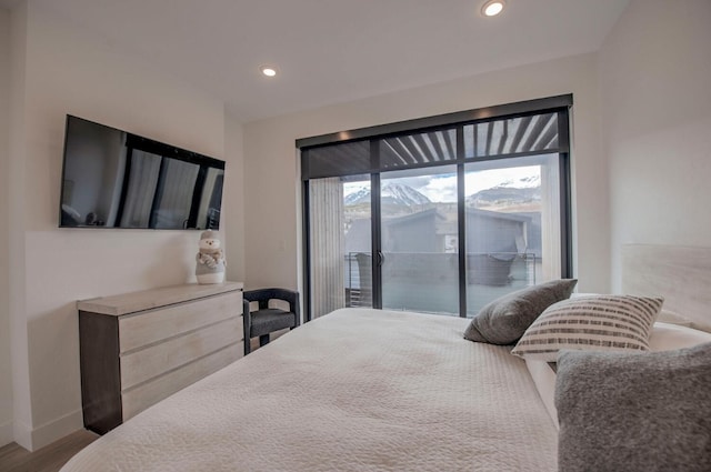 bedroom with hardwood / wood-style floors and access to outside