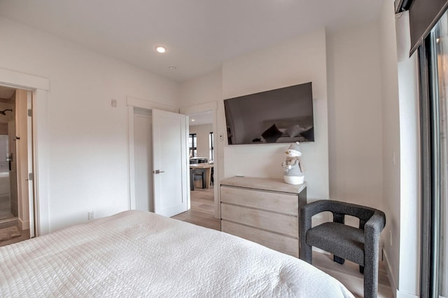 bedroom with wood-type flooring and ensuite bathroom