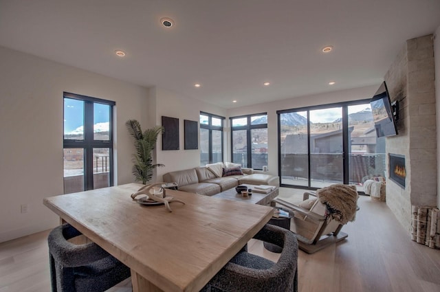 dining area featuring a fireplace and light wood-type flooring