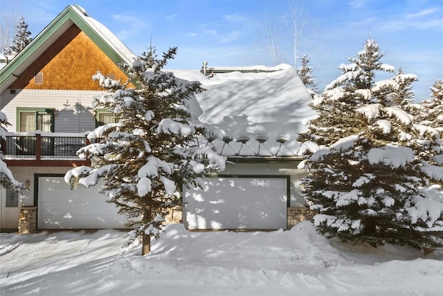 view of snowy exterior featuring a garage