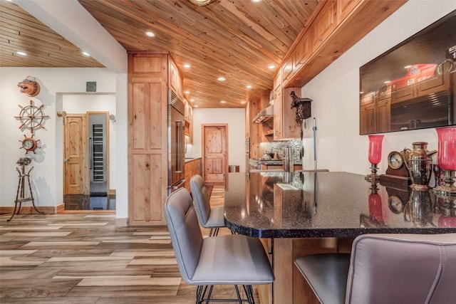 kitchen with decorative backsplash, light hardwood / wood-style flooring, and wooden ceiling