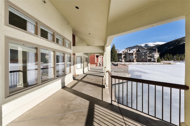 snow covered back of property with a mountain view