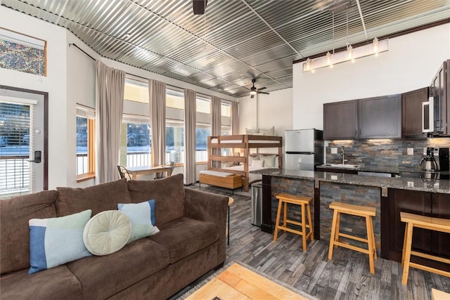 living room with ceiling fan, dark wood-type flooring, and sink